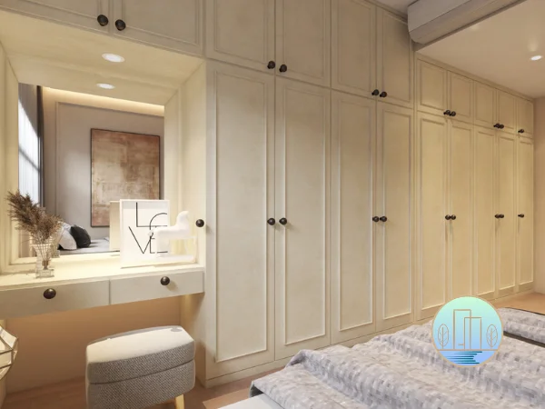 A modern bedroom interior features floor-to-ceiling cream American classic-style wardrobes next to a built-in vanity with an ambient lighting mirror and a grey upholstered stool.