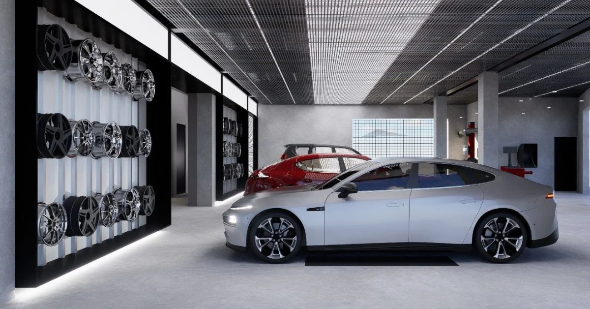 Commercial Tyre Shop Design Luxury commercial Tyre shop design. A modern automotive service bay featuring a silver sedan, a red crossover, and a wall display of various alloy wheels under a light weight mesh metal grate ceiling.