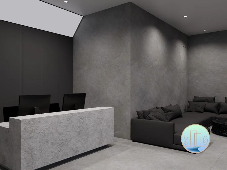 luxury commercial office design for tyre shop Modern reception area featuring a textured gray stone desk, dark minimalist walls, and a matching dark sectional sofa under recessed lighting.